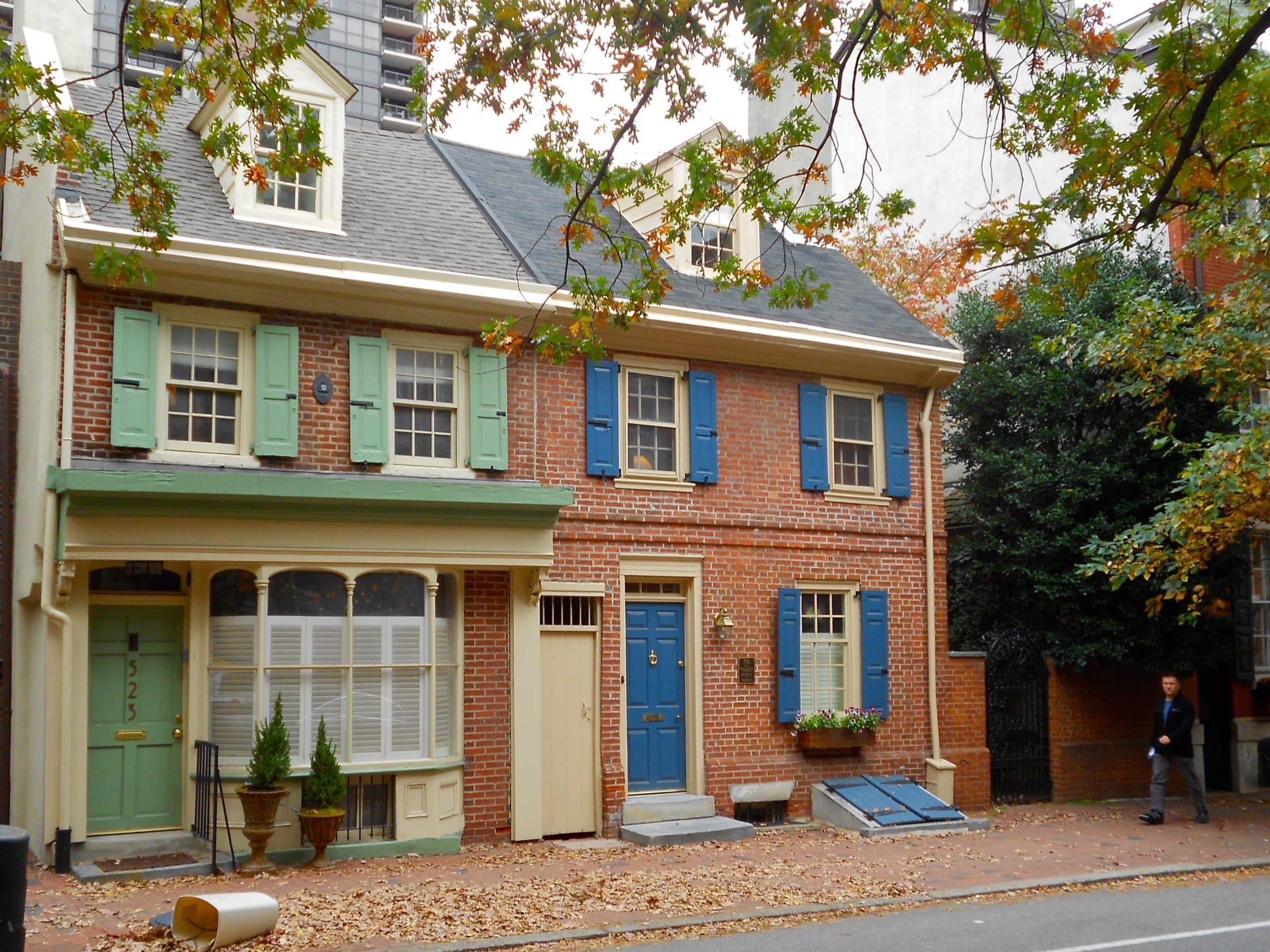Brick rowhomes with shutters on a Philadelphia street